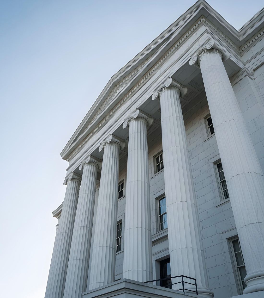 Columns of a courthouse against a clear sky